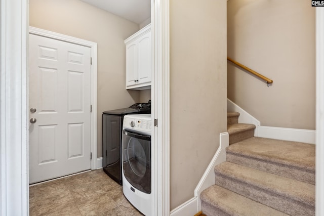 washroom with cabinets and washing machine and clothes dryer