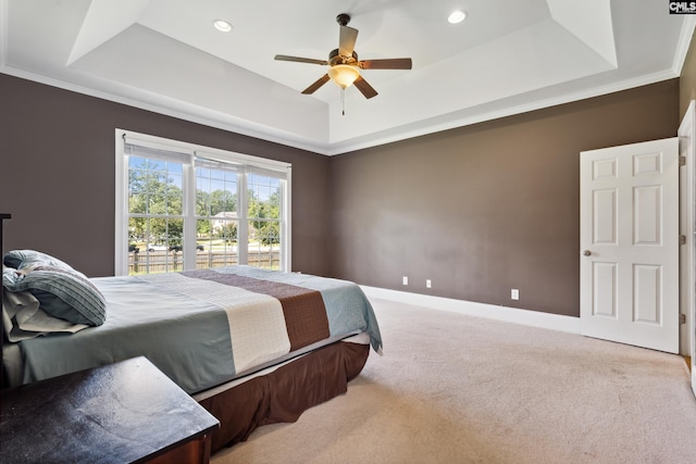 bedroom featuring ornamental molding, carpet flooring, a tray ceiling, and ceiling fan