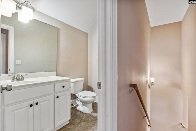 bathroom with toilet, lofted ceiling, and vanity