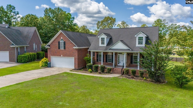 cape cod house with covered porch, a garage, and a front yard