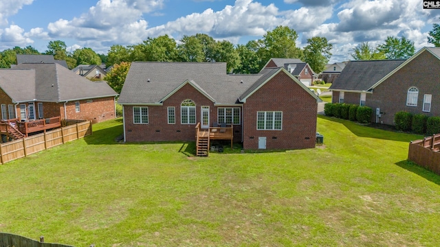 back of property with a yard and a wooden deck