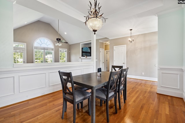 dining room with ornamental molding, vaulted ceiling, light hardwood / wood-style flooring, and ceiling fan with notable chandelier