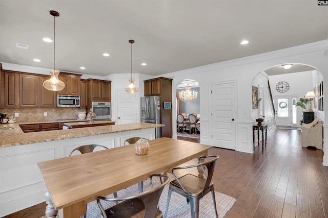 dining room featuring french doors, dark hardwood / wood-style floors, ornamental molding, and a notable chandelier