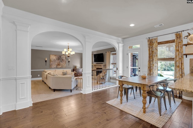 dining space featuring an inviting chandelier, ornamental molding, and hardwood / wood-style floors