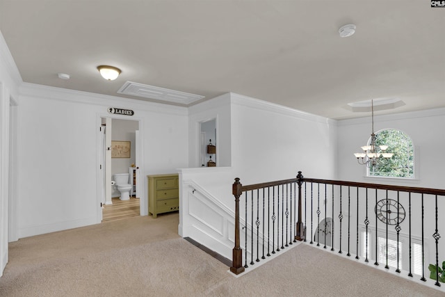 corridor featuring light carpet, crown molding, and an inviting chandelier