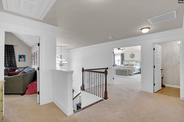 corridor with light carpet, a notable chandelier, and ornamental molding