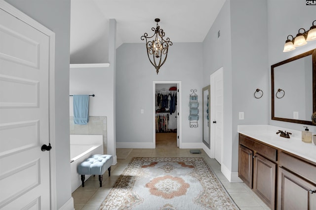 bathroom with tile patterned flooring, vanity, a tub, and a notable chandelier