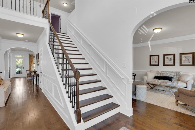 staircase featuring crown molding and hardwood / wood-style floors