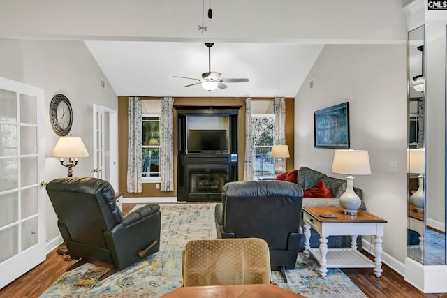 living room featuring dark hardwood / wood-style floors, ceiling fan, and vaulted ceiling