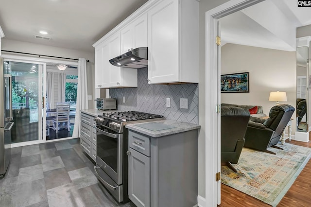 kitchen featuring dark wood-type flooring, white cabinetry, high end stove, and backsplash