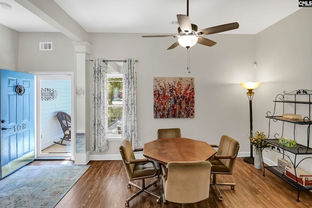 dining room with hardwood / wood-style flooring, ornate columns, and ceiling fan