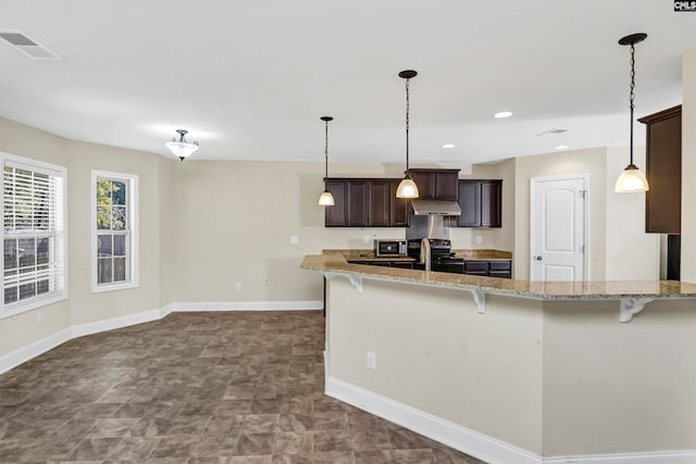 kitchen with light stone counters, dark brown cabinetry, and kitchen peninsula