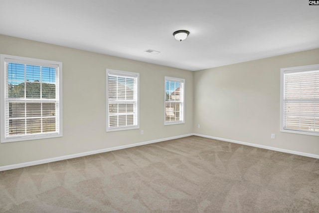 carpeted empty room featuring a healthy amount of sunlight