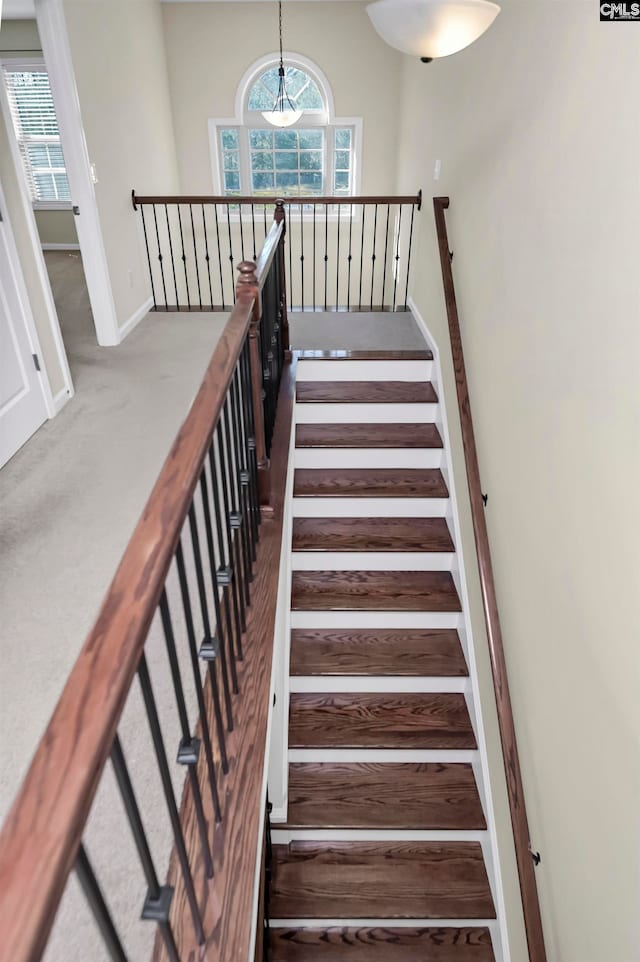 stairway featuring a chandelier