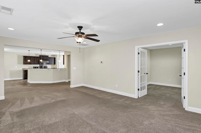 unfurnished living room featuring ceiling fan and dark carpet