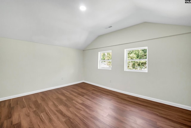 spare room with vaulted ceiling and hardwood / wood-style floors