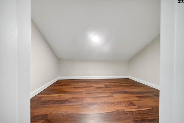 bonus room with lofted ceiling and dark hardwood / wood-style flooring