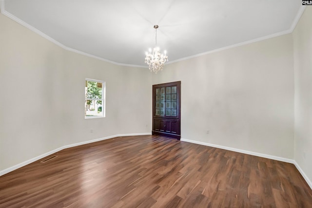 spare room featuring ornamental molding, a notable chandelier, and dark hardwood / wood-style floors