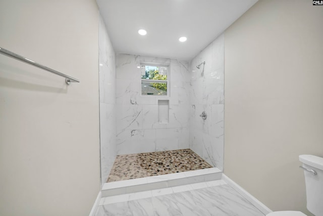 bathroom featuring toilet and a tile shower