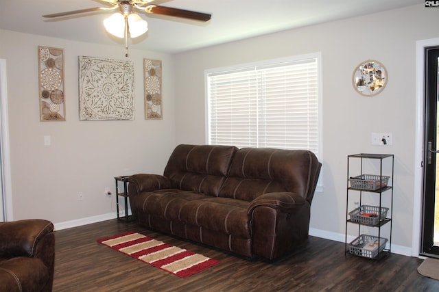 living room featuring dark wood-type flooring and ceiling fan