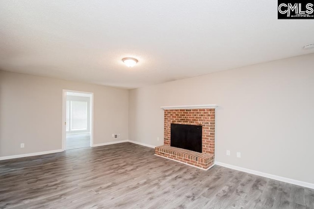 unfurnished living room featuring a fireplace and hardwood / wood-style flooring