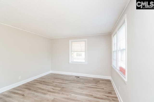 unfurnished room featuring light hardwood / wood-style floors and ornamental molding