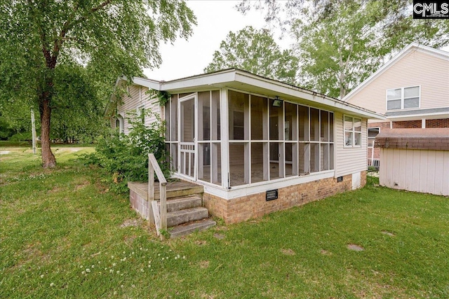 view of side of home with a yard and a sunroom