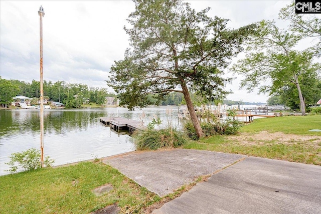 dock area with a water view and a yard