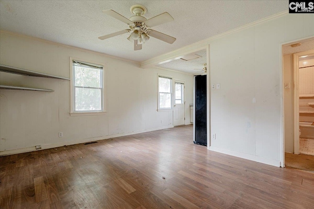 spare room with ornamental molding, a textured ceiling, wood-type flooring, and ceiling fan