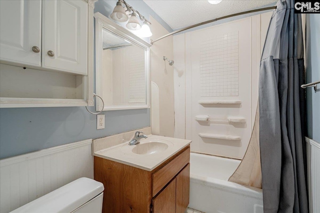 full bathroom featuring toilet, a textured ceiling, shower / tub combo with curtain, and vanity