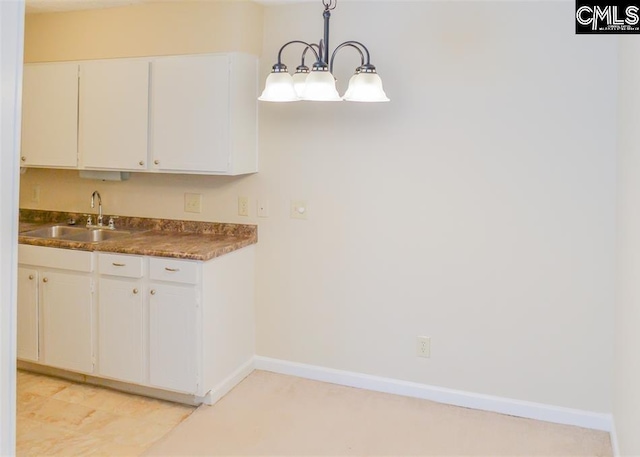 kitchen with sink, white cabinetry, and pendant lighting