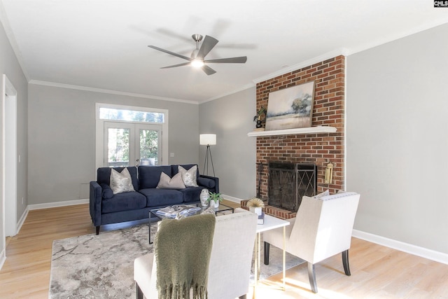 living room with ornamental molding, light hardwood / wood-style flooring, a fireplace, and ceiling fan