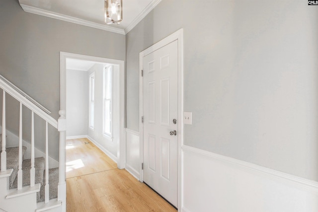 foyer featuring crown molding and light wood-type flooring