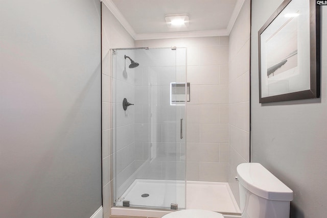 bathroom with ornamental molding, toilet, and an enclosed shower