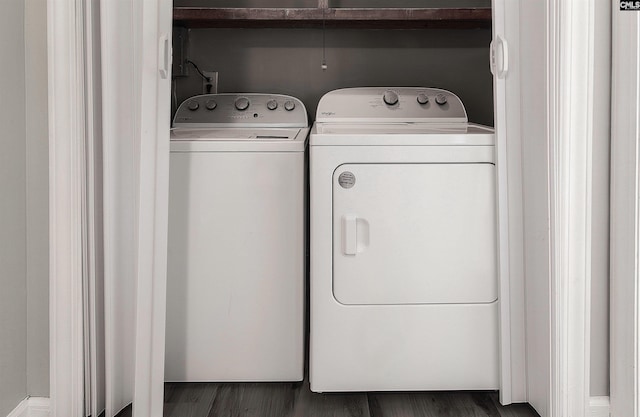 clothes washing area with dark hardwood / wood-style floors and separate washer and dryer