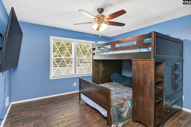 bedroom with a textured ceiling, ceiling fan, and dark hardwood / wood-style flooring