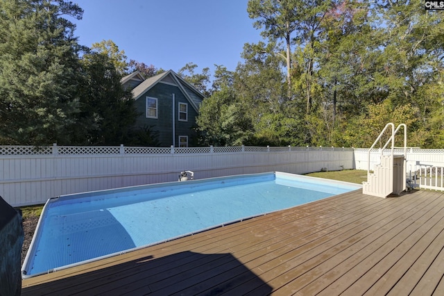 view of pool with a wooden deck, a fenced in pool, a fenced backyard, and a water slide
