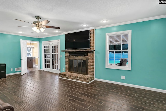 unfurnished living room with a textured ceiling, a brick fireplace, dark hardwood / wood-style floors, and ceiling fan with notable chandelier