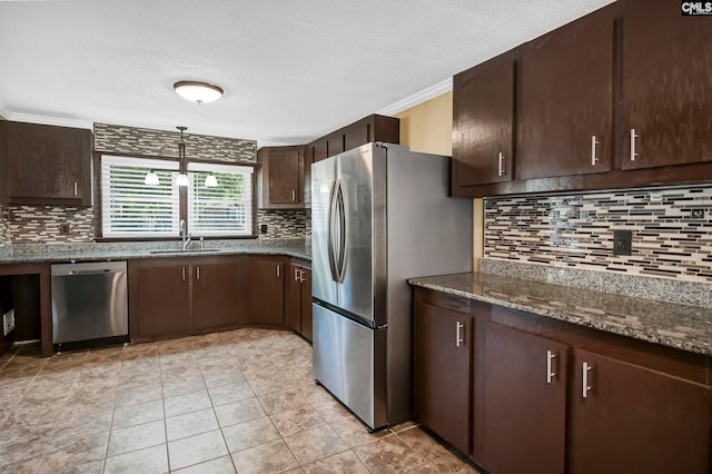 kitchen with stainless steel appliances, dark stone countertops, ornamental molding, dark brown cabinetry, and tasteful backsplash