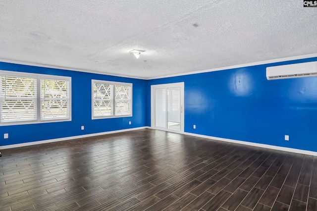 empty room featuring ornamental molding, a textured ceiling, a wall mounted air conditioner, and hardwood / wood-style flooring