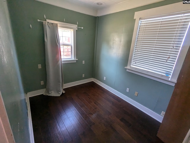 empty room with wood-type flooring and baseboards