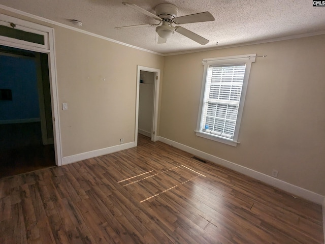 unfurnished bedroom featuring ornamental molding, ceiling fan, a textured ceiling, and dark hardwood / wood-style flooring