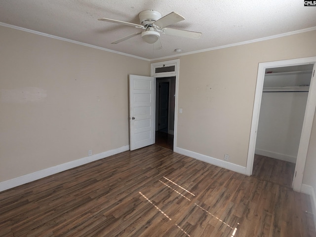 unfurnished bedroom featuring crown molding, a textured ceiling, dark wood-type flooring, and ceiling fan