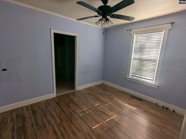 empty room with ornamental molding, electric panel, ceiling fan, and dark hardwood / wood-style flooring