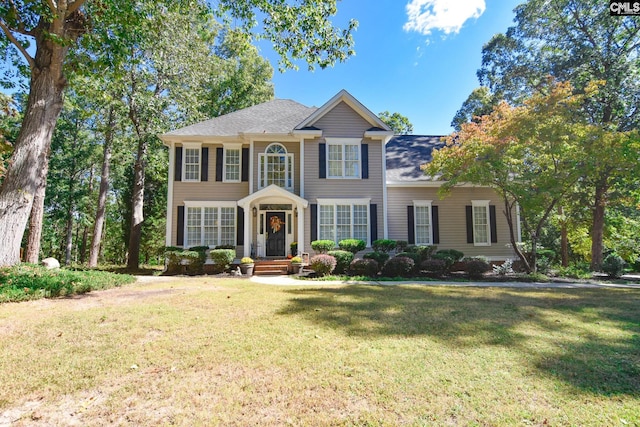 colonial-style house featuring a front lawn