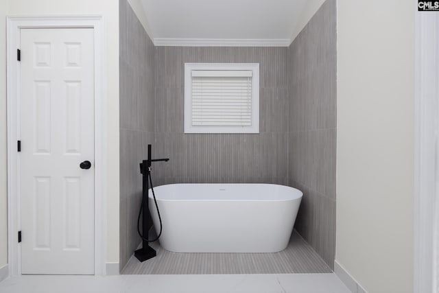 bathroom featuring a tub to relax in, tile walls, ornamental molding, and tile patterned flooring