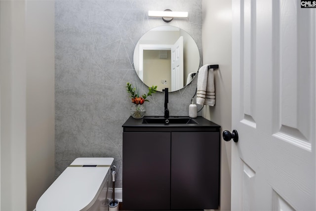 bathroom featuring toilet, vanity, and tile walls