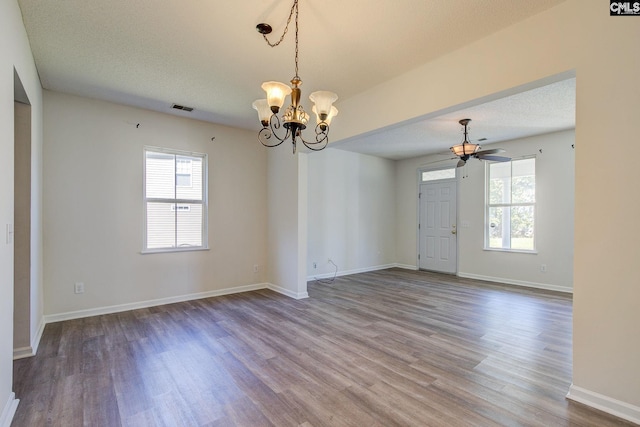 spare room with a textured ceiling, hardwood / wood-style flooring, and ceiling fan with notable chandelier