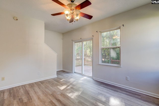 unfurnished room with light hardwood / wood-style flooring, a textured ceiling, and ceiling fan