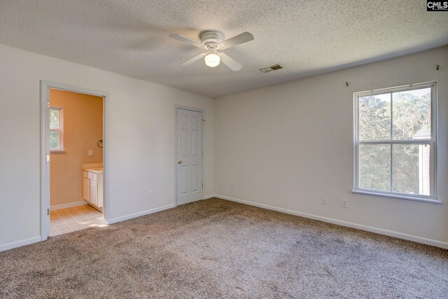 unfurnished room featuring a textured ceiling, light colored carpet, and ceiling fan